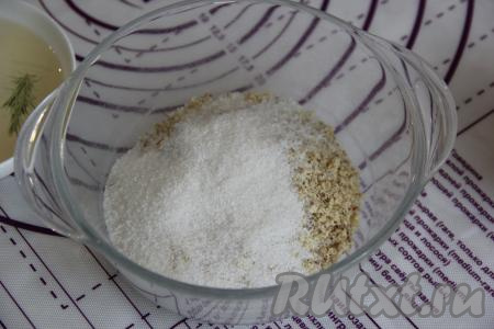 Орехи (у - меня грецкие) измельчить в мелкую крошку (можно порубить ножом). В миске соединить ореховую крошку и сахар.