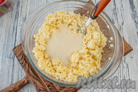 В получившуюся творожную массу всыпьте манную крупу, хорошо перемешайте и оставьте на 8-10 минут, чтобы манка смогла набухнуть. Если творог у вас достаточно влажный, то можно добавить ещё 1-2 столовых ложки манки. Творожная масса в итоге должна получиться достаточно плотной, чтобы она держалась на ложке.