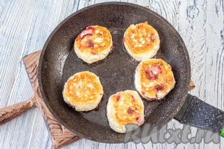 Аккуратно переверните сырники и готовьте ещё 3 минуты до румяной корочки со второй стороны под крышкой. Сырники должны жариться именно на небольшом огне, чтобы внутри они смогли как следует прожариться.