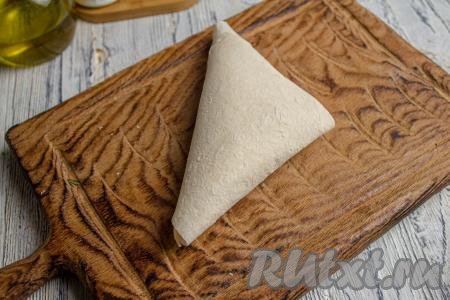 Далее сформированный треугольник продолжайте заворачивать, двигаясь по граням треугольника до конца полоски лаваша.&nbsp;