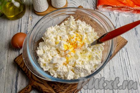 Творог выложите в подходящую посуду, вбейте 1 куриное яйцо, посолите и поперчите по вкусу, перемешайте.&nbsp;