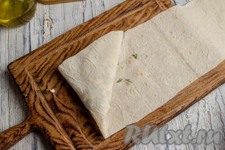 Уголок лаваша, ближний к вам на фото, заверните вверх, формируя треугольник.&nbsp;