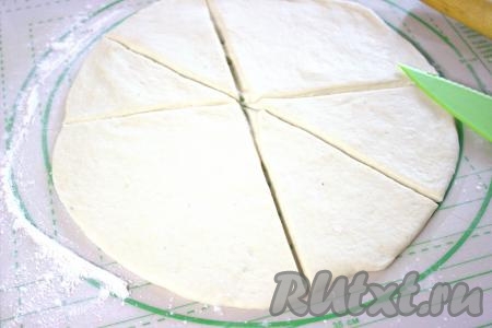 Поднявшееся тесто обмять, раскатать его на присыпанной мукой поверхности в круг диаметром 25-30 сантиметров и толщиной 1,5-2 сантиметра. Я тесто разделила перед раскаткой на 2 неравные части. Большую часть раскатанного теста разделила на 10 секторов, а меньшую часть теста раскатала и разделила на 6 секторов.