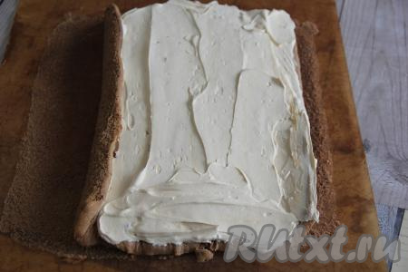 Бисквит аккуратно развернуть, убрать пергамент. Смазать бисквит кремом из сливок и сгущёнки.