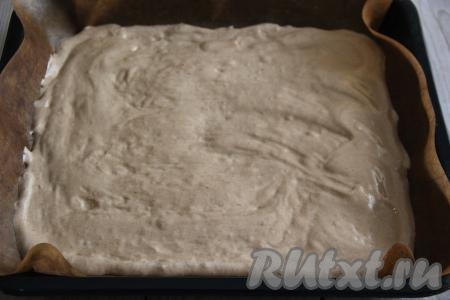 Противень (у меня размер противня 30 сантиметров на 30 сантиметров) выстелить пергаментом, затем выложить бисквитное тесто и аккуратно разровнять лопаткой.