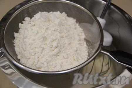 Всыпать разрыхлитель в получившуюся смесь и начать частями добавлять просеянную муку, перемешивая тесто для кексов лопаткой.