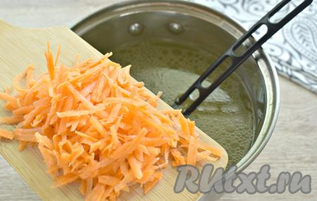 Натираем на средней тёрке очищенную морковку, перекладываем её в куриный бульон, доводим до кипения, а затем варим минут 10 на умеренном огне.