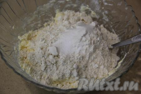 Отдельно смешать просеянную муку с разрыхлителем и ванилином. Получившуюся мучную смесь небольшими порциями всыпать в миску с творожной массой, вначале вмешивая муку в тесто вилкой. Затем переложить на силиконовый коврик (или припылённый мукой стол) и, добавляя частями оставшуюся мучную смесь, хорошо вымесить творожное тесто руками.