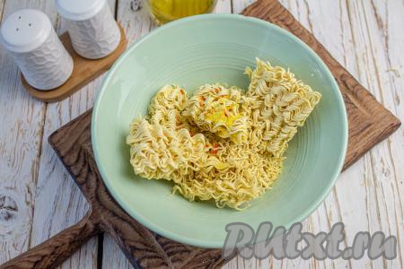 В подходящую глубокую посуду выложите лапшу и добавьте специи. Я добавила специи по типу кубика от Галины Бланки в рассыпчатом виде, но можно использовать те специи, которые идут в упаковке с лапшой "Доширак".