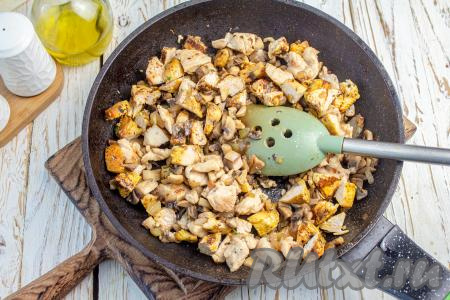 Куриное филе нарежьте на небольшие кубики, добавьте в сковороду с луком и грибами, обжарьте на сильном огне, иногда помешивая, до побеления кусочков мяса, сильно зажаривать не надо. Всыпьте куркуму, орегано, соль и чёрный молотый перец. Затем курино-грибную начинку снимите с плиты, дайте немного остыть.