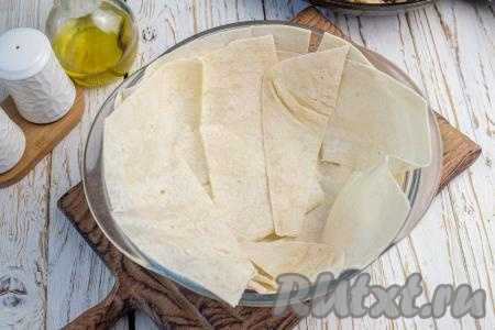 Форму для выпечки с бортиками высотой 4-5 сантиметров (я взяла форму диаметром 18 сантиметров) смажьте растительным маслом. Лист лаваша разрежьте пополам и уложите в форму в два слоя до уровня бортиков формы.