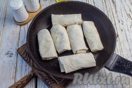 На сковороде нагрейте растительное масло, выложите часть заготовок швом вниз и обжаривайте на среднем огне в течение нескольких минут (до подрумянивания) с одной стороны.