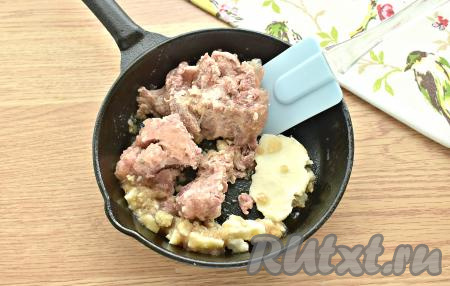 На горячую сковороду, где жарились овощи, выкладываем тушёнку из банки. На среднем огне разогреваем тушёнку, разбивая лопаточкой крупные куски мяса, приблизительно 3-4 минуты. Жир за это время превратится в бульон. Подготовленную таким образом тушёнку добавляем в щи, даём закипеть, а после этого варим на небольшом огне ещё 5 минут.