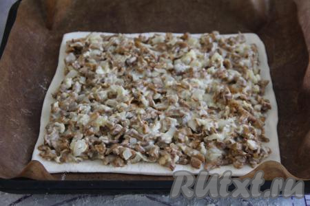 Выложить грибную начинку на тесто, оставив чистыми края, и разровнять.