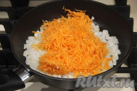 Когда лук станет золотистым, выложить к нему морковку, натёртую на мелкой тёрке.