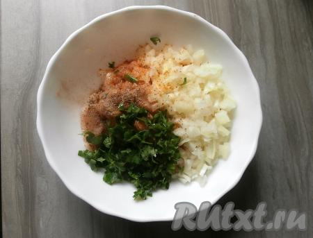 Луковицу очистить и нарезать её мелко. К нарезанному куриному мясу добавить нарезанные петрушку и лук, поперчить, всыпать специи, посолить.