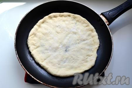 Разделить тесто на 2 части, каждую - раскатать в лепёшку по диаметру сковороды. Можно сразу готовить пиццу на двух сковородах, если есть. Сковороду смазать растительным маслом и выложить лепёшку.
