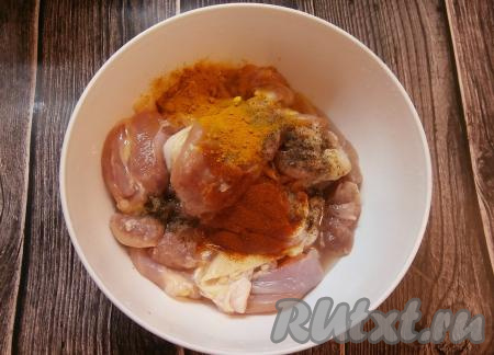 К нарезанному куриному мясу добавить чёрный молотый перец, куркуму и паприку.