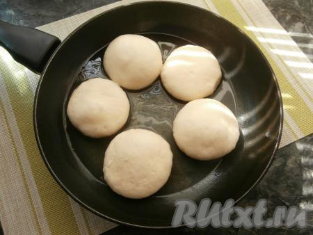 В сковороде разогреть растительное масло, выложить часть заготовок пончиков.