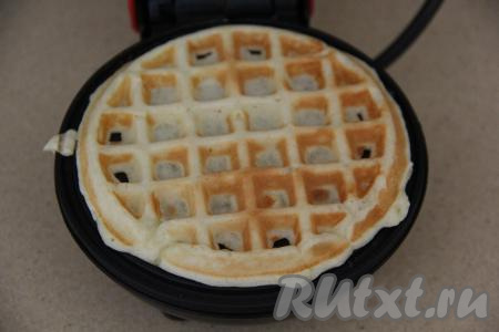 Плотно закрыть створки электровафельницы, выпекать вафлю до золотистого цвета, затем переложить на тарелку. Периодически перемешивая творожную массу и смазывая створки вафельницы только по мере необходимости, постепенно испечь все вафли.