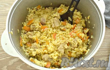 Доводим воду до кипения, накрываем казан (или сковороду) крышкой, убавляем огонь до минимального. Варим плов из пропаренного риса со свининой 30 минут.