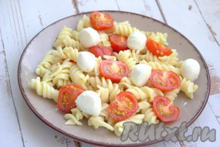 Поверх пасты с помидорами черри выложить сыр моцарелла.