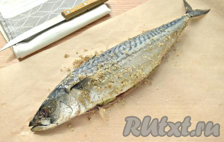 Расстилаем на столе большой кусок пергаментной бумаги. Помещаем на неё скумбрию в специях.