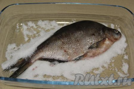 В жаропрочную форму (или на противень) выложить, примерно, 350 грамм соли. Соль должна лежать не тонким слоем. Выложить леща поверх соли.&nbsp;