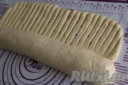 Свернуть тесто с начинкой в рулет, начиная с края, противоположенного краю с полосками. Тесто сворачиваем до начала полосок. Защепить края теста руками с двух боков рулета.