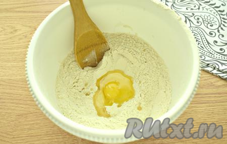 В получившееся углубление вливаем растительное масло и разбиваем куриное яйцо.