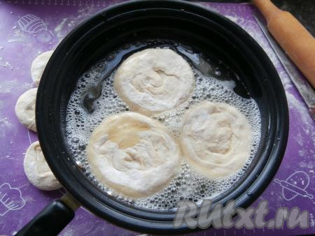 Затем каждую получившуюся лепёшку раскатать скалкой так, чтобы толщина лепёшки была около 0,5 сантиметра. Растительное масло хорошо разогреть в сковороде, выложить несколько лепёшек.