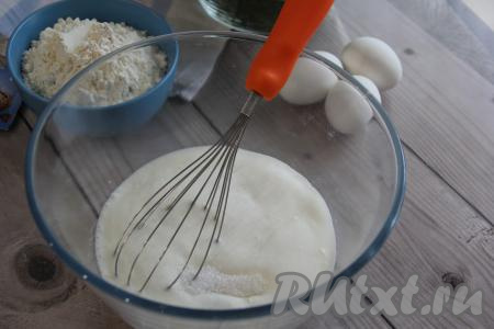 Прежде всего нужно замесить тесто, для этого кефир нужно влить в объёмную миску, добавить соду, хорошо перемешать и оставить на 5-7 минут (за это время произойдёт реакция, в ходе которой сода погасится в кефире). Затем в смесь кефира и соды всыпать соль и сахар, перемешать венчиком.