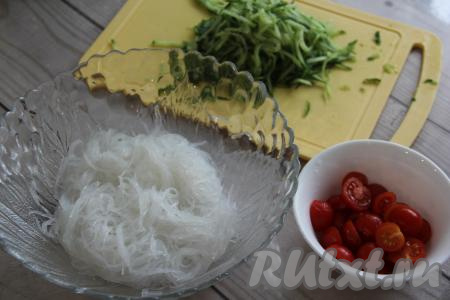 Нарезать фунчозу с помощью ножниц и переложить в салатник. Помидоры черри разрезать пополам. Если используете крупные помидоры, то нарезать их на небольшие дольки.