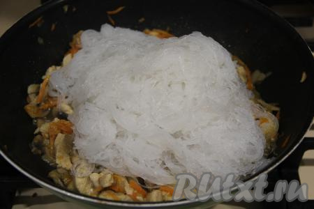 По прошествии 5 минут фунчозу откинуть на дуршлаг, промыть её холодной водой и оставить на несколько минут, чтобы стекла лишняя вода. Затем нарезать фунчозу с помощью ножниц на более мелкие фрагменты. А после того как курица с шампиньонами и овощами обжарится минут 15, добавить фунчозу в сковороду, перемешать.