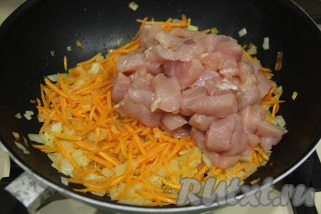 Обжаривать морковь с луком 5 минут, помешивая время от времени, чтобы овощи не пригорели. Когда овощи станут достаточно мягкими, добавить к ним куриное филе, нарезанное на небольшие кубики (или брусочки), перемешать.