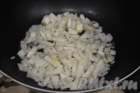 В сковороду влить масло и разогреть. Лук нарезать на кубики. Выложить лук в сковороду и обжаривать его минут 5 на среднем огне, помешивая.
