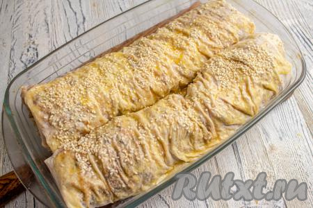 Подготовленные рулеты из лаваша с капустой переложите в форму для запекания, смажьте остатками яйца и, по желанию, присыпьте кунжутом. Запекайте в разогретой духовке 15-20 минут при температуре 190-200 градусов.