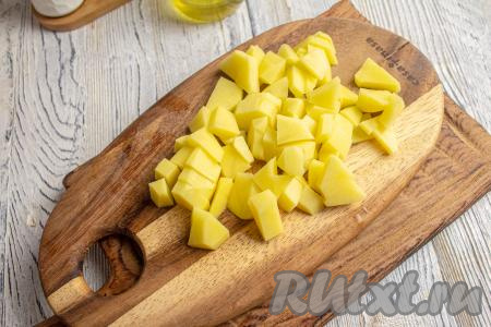 Картофель очистите, нарежьте на небольшие кубики, хорошо промойте. В кастрюле вскипятите 1,5-2 литра воды, добавьте картофель, дайте снова воде закипеть, а затем на небольшом огне варите 7-8 минут.