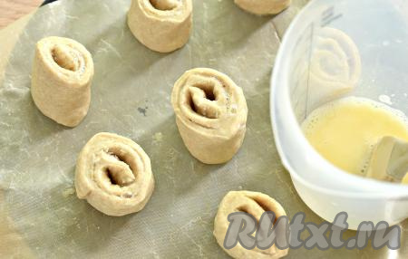 Заготовки булочек ставим срезом вверх на противень, застеленный пергаментом. Поверхность булочек смазываем взбитым яйцом. Всего у меня получилась 21 булочка.