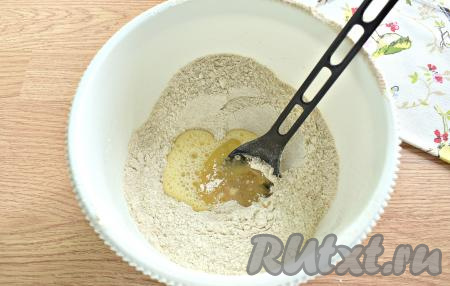 Одно яйцо в отдельной ёмкости взбиваем вилкой, а затем вливаем в "воронку", сделанную в смеси муки и дрожжей. Следом вливаем 30 миллилитров растительного масла.
