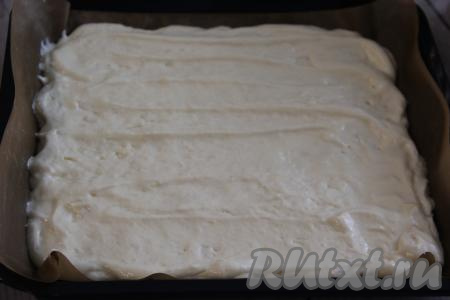 Выложить тесто поверх яблок и равномерно распределить.