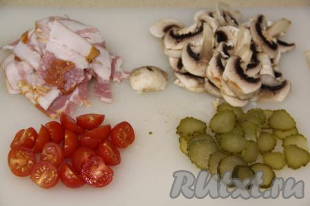 Пока тесто для пиццы отдыхает, можно подготовить начинку. Шампиньоны промыть, убирая загрязнения, немного обсушить и нарезать грибы на пластинки. Огурчик нарезать на кружочки. Помидоры черри разрезать пополам (если вы готовите с обычными помидорами, тогда нарежьте их на кружочки). Бекон нарезать на тонкие ломтики.
