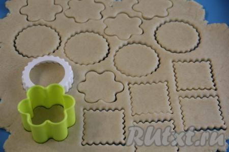 На слегка присыпанной мукой поверхности тесто нужно раскатать скалкой в пласт толщиной, примерно, 0,5 сантиметра и с помощью вырубки для печенья (или с помощью стакана, или чашки) вырезать печенюшки любой формы.