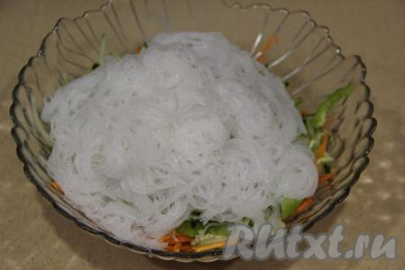 По истечении 5 минут фунчозу откинуть на дуршлаг, затем её нужно промыть холодной водой и оставить на несколько минут в дуршлаге, чтобы стекла лишняя жидкость. Нарезать фунчозу ножницами и выложить в салатник с овощами.&nbsp;