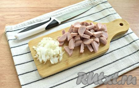 Сосиски, очищенные от слюды, нарезаем на полукружочки. Половину очищенной луковицы мелко нарезаем.