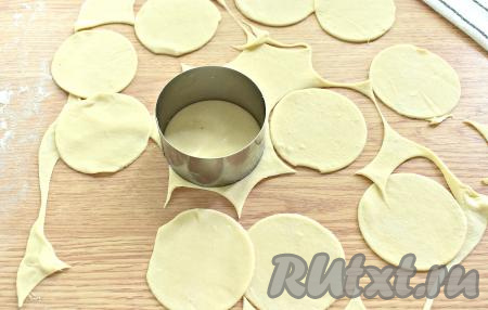 Тесто достаём из холодильника, делим на 4-5 кусков. Каждый кусок теста на припылённой мукой поверхности раскатываем в тонкий пласт (толщиной, примерно, 2 миллиметра). С помощью кулинарного кольца (или подходящей чашки) вырезаем кружочки.