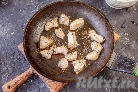 В сковороду налейте растительное масло, выложите куриное филе, обжаривайте до готовности, периодически переворачивая, на среднем огне. На обжаривание у вас уйдёт, примерно, 6-8 минут. В процессе жарки кусочки филе приправьте сушёным базиликом и чёрным молотым перцем. Готовое мясо переложите на тарелку.