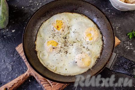 В эту же сковороду вбейте яйца и на масле, на котором жарилась курица, жарьте яичницу под крышкой до готовности (желток не должен быть жидким), не забыв поперчить и посолить по вкусу. 