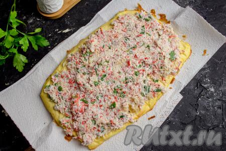 На остывший омлет распределите ровным слоем начинку.