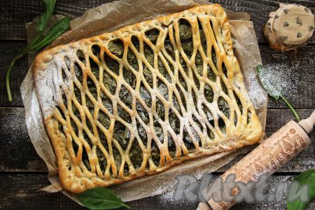 Готовый вкусный, сочный слоёный пирог со щавелем слегка остудить, а затем переложить на тарелку и нарезать на кусочки.